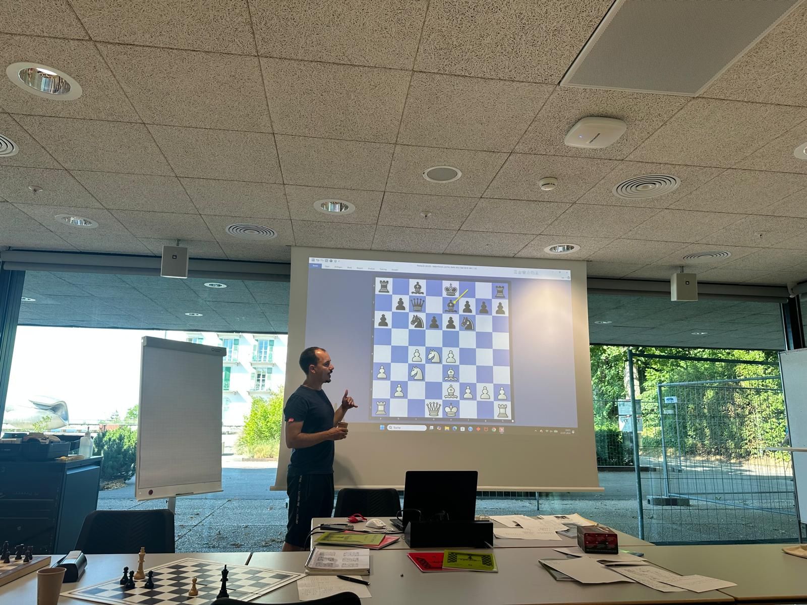 Trainer erklärt eine Schachstellung auf der Projektionsleinwand im Seminarraum in Magglingen